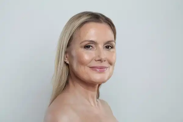 Dojrzała kobieta nakłada krem na twarz